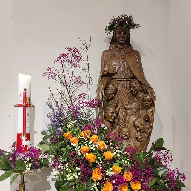 Statue der Gottesmutter Maria und Osterkerze in der St. Nikolaus Kirche mit Blumenschmuck anlässlich Darstellung des Herrn/ Mariä Lichtmess 2025