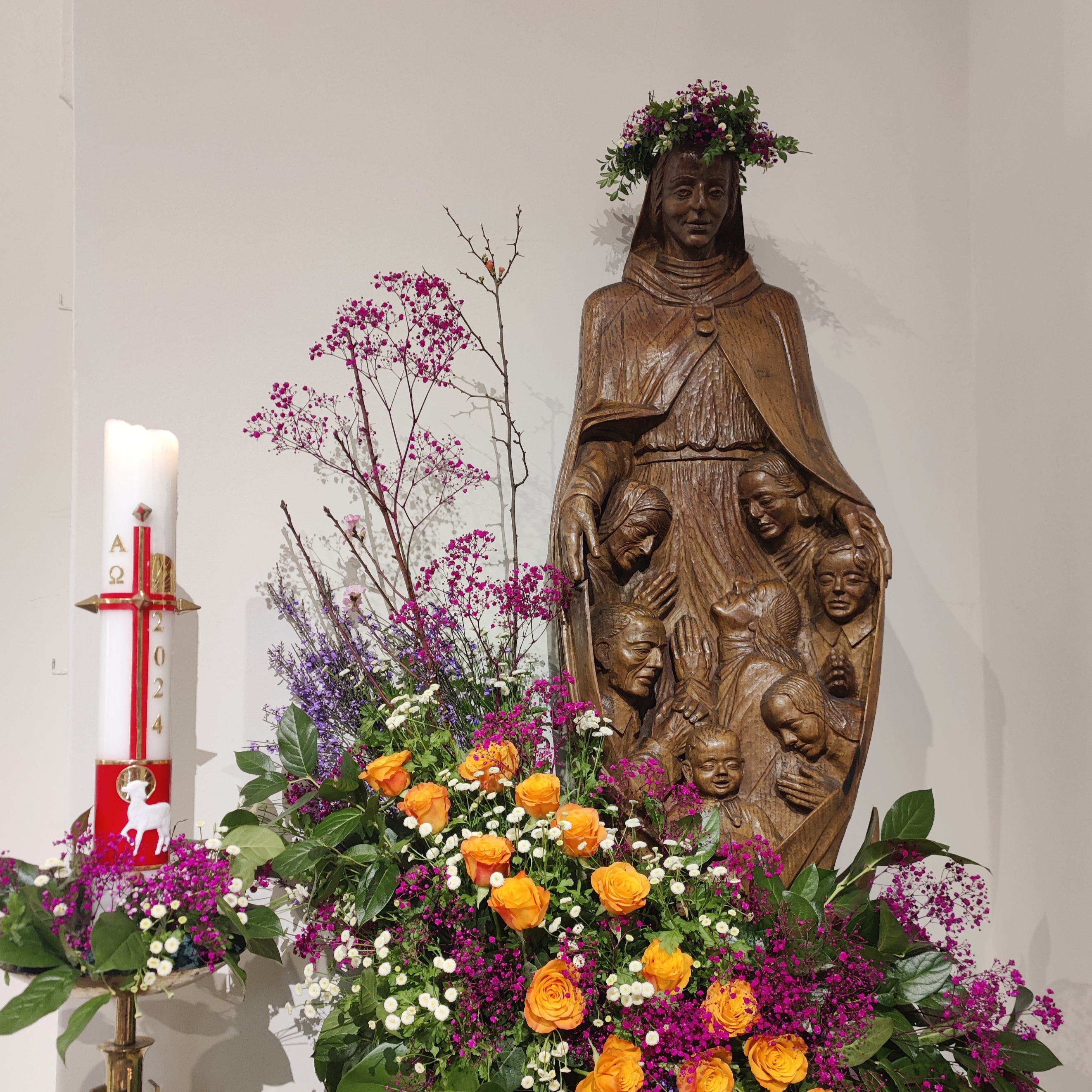 Statue der Gottesmutter Maria und Osterkerze in der St. Nikolaus Kirche mit Blumenschmuck anlässlich Darstellung des Herrn/ Mariä Lichtmess 2025